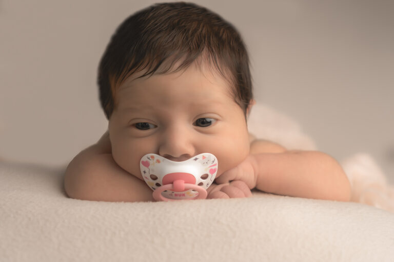 Bébé réveillé avec sa tétine dans la bouche lors d'un shooting nouveau-né à mon home studio sur bordeaux
