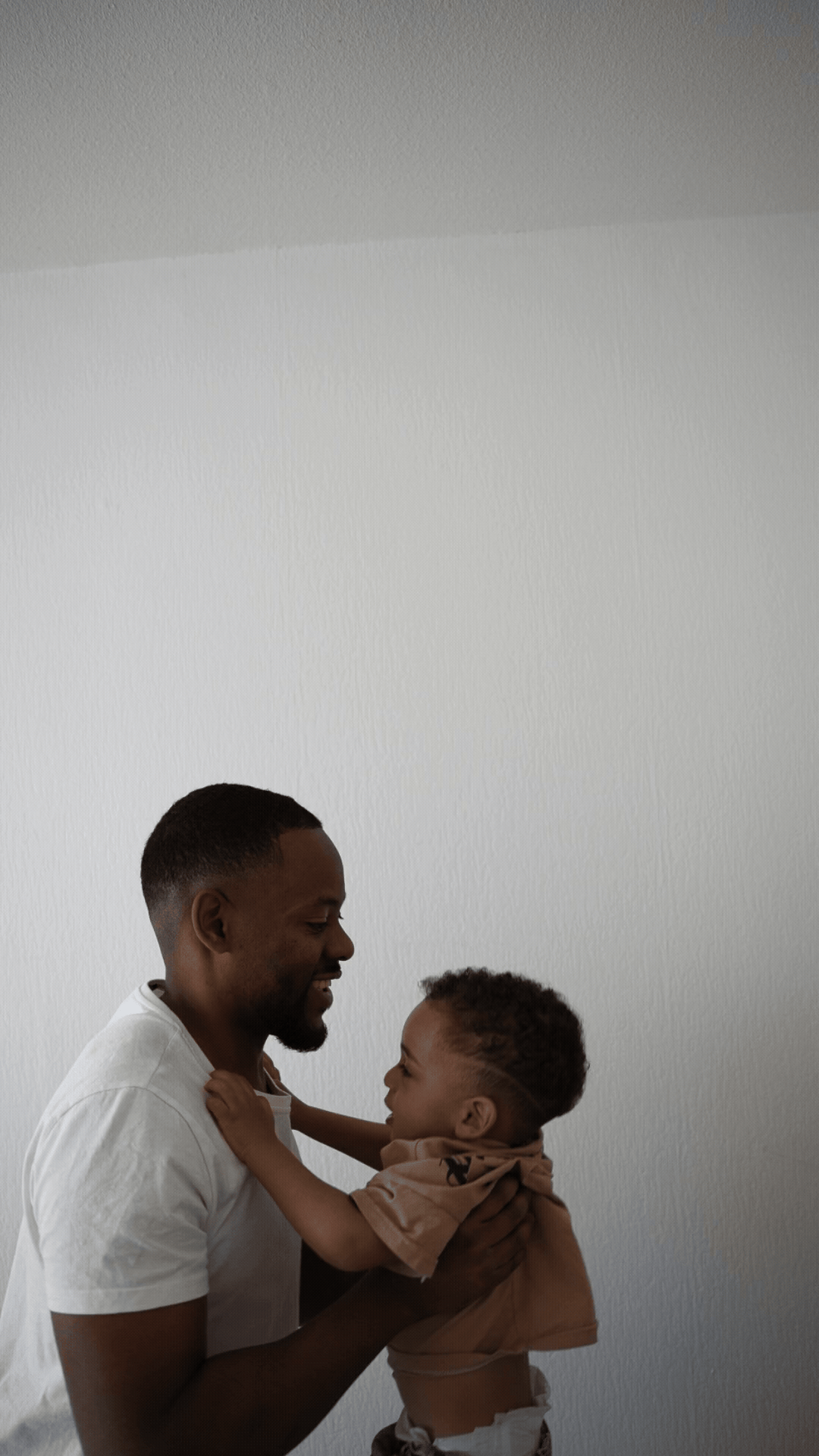Gif d'un papa qui lance son fils en l'air pour jouer lors d'une séance photo famille à domicile à Pessac