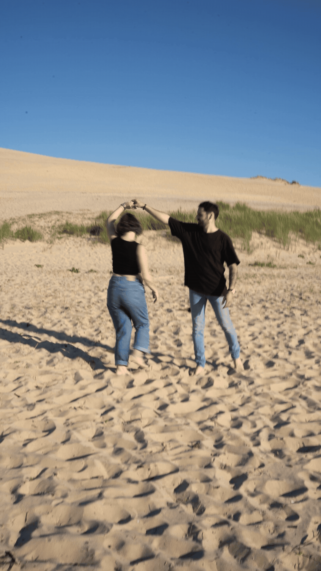 Femme enceinte qui danse avec son mari lors d'une séance à la plage aux dunes du pilat