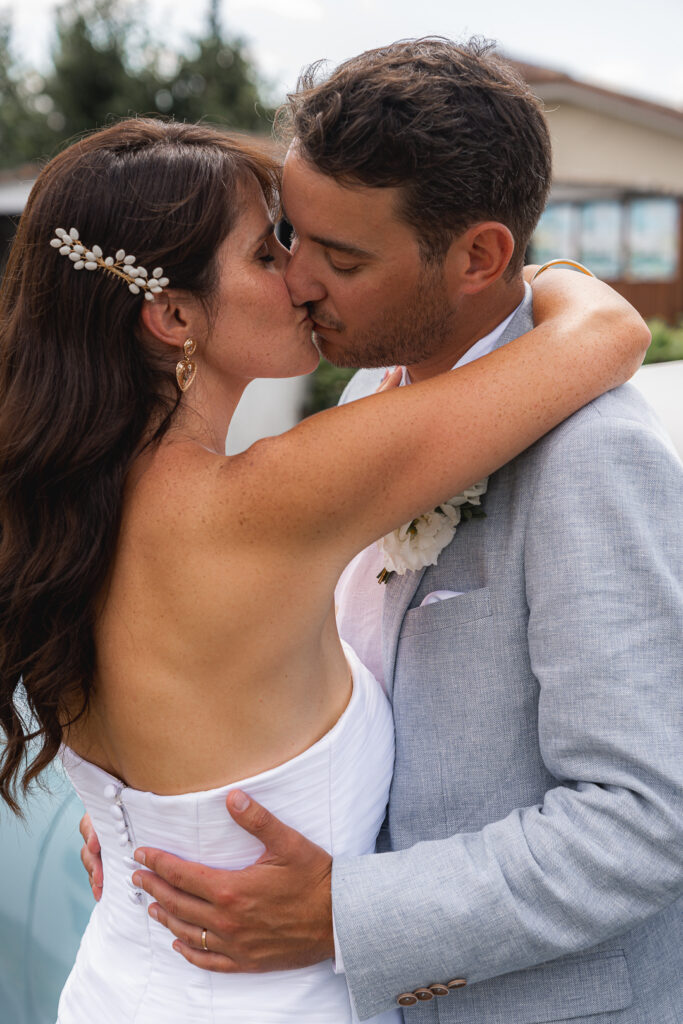 Jeunes mariés qui s'embrassent lors de la séance couple de leur mariage civil à Salleboeuf