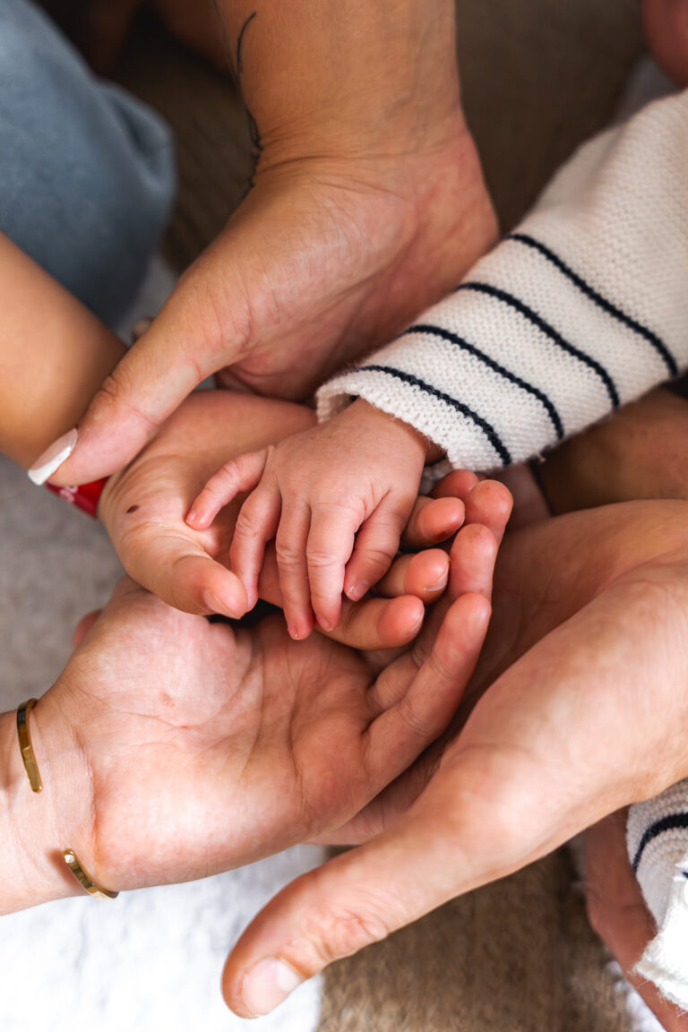 Détails des mains des membres de toutes la famille lors d'un shooting bébé à domicile à Mios sur le Bassin d'Arcachon