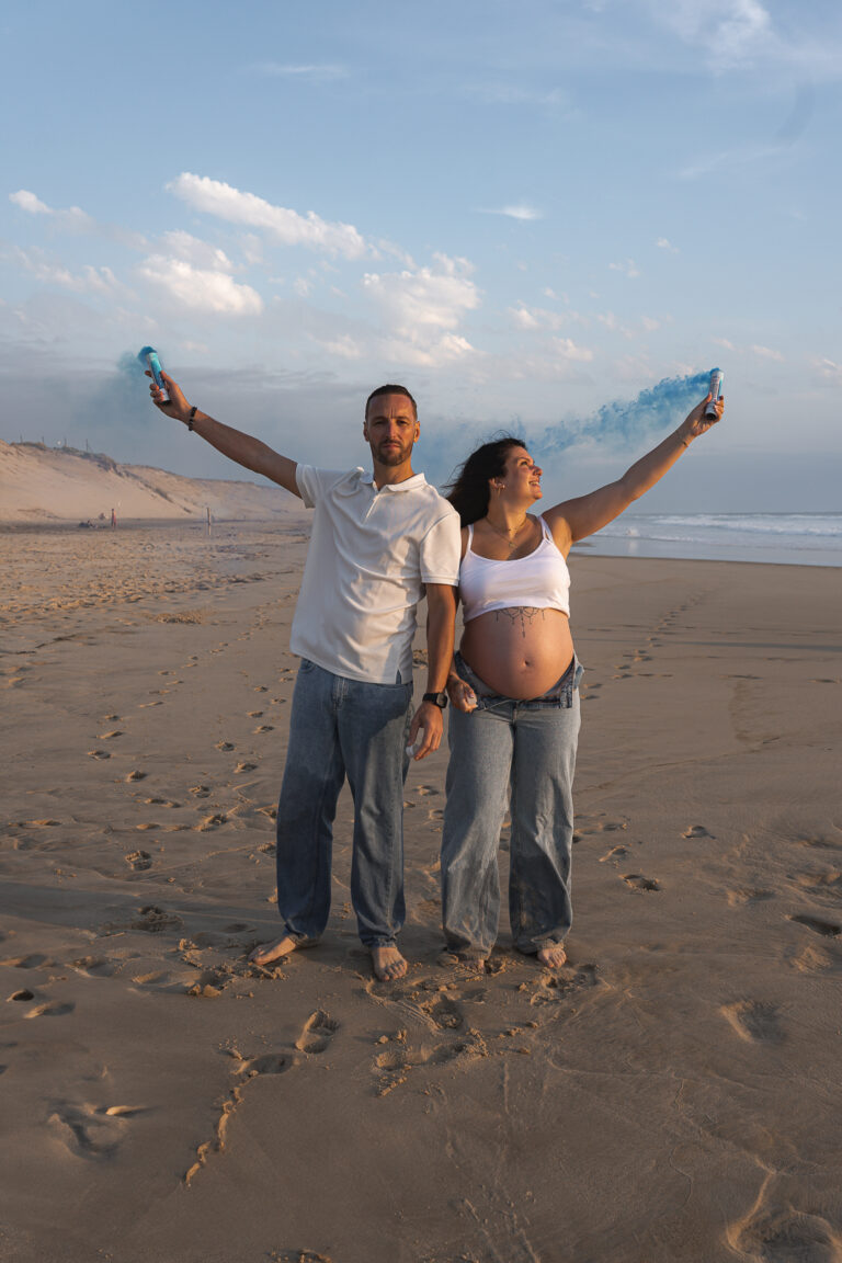 Futurs parents qui découvrent le sexe de leur enfant grâce à des fumigènes lors de leur shooting grossesse à la plage de Biscarosse sur le Bassin d'Arcachon