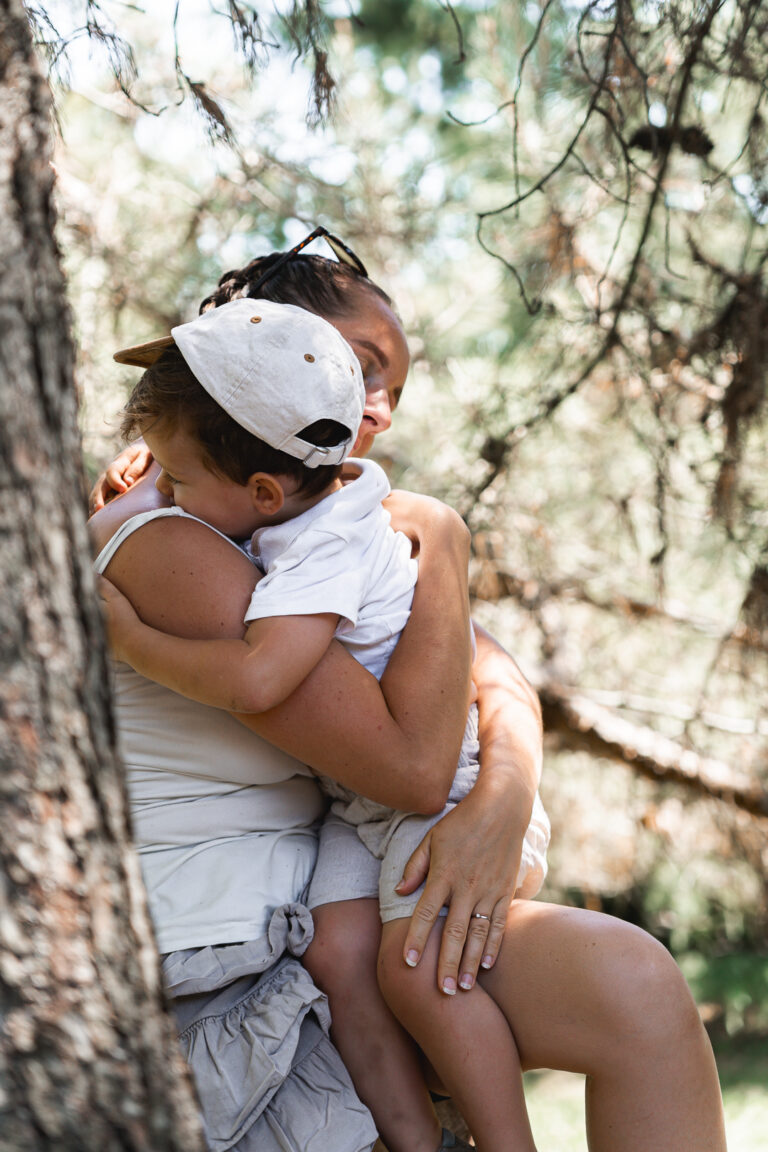 Maman qui fait un câlin à son enfant sur un arbre lors d'une mini-séance photo "Maman & moi" en extérieur à Talence à l'occasion de la fête des mères