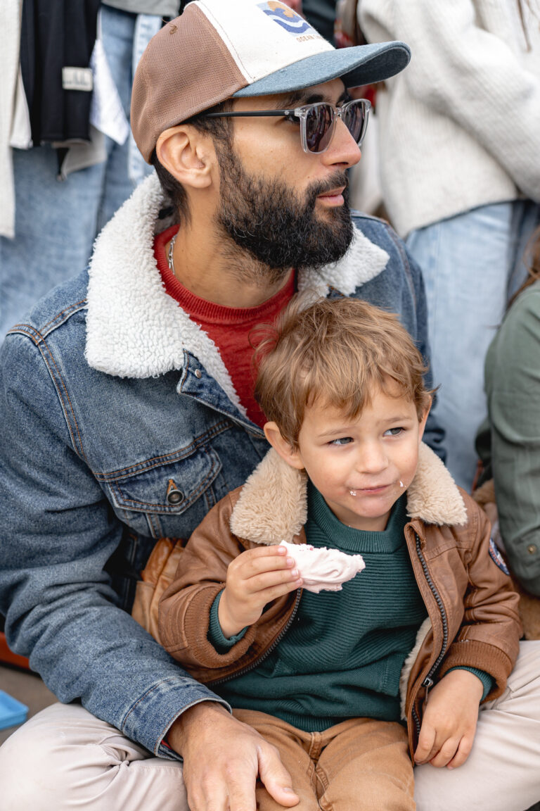 Papa qui tient son enfant qui mange un gateau sur la place de la bourse à Bordeaux
