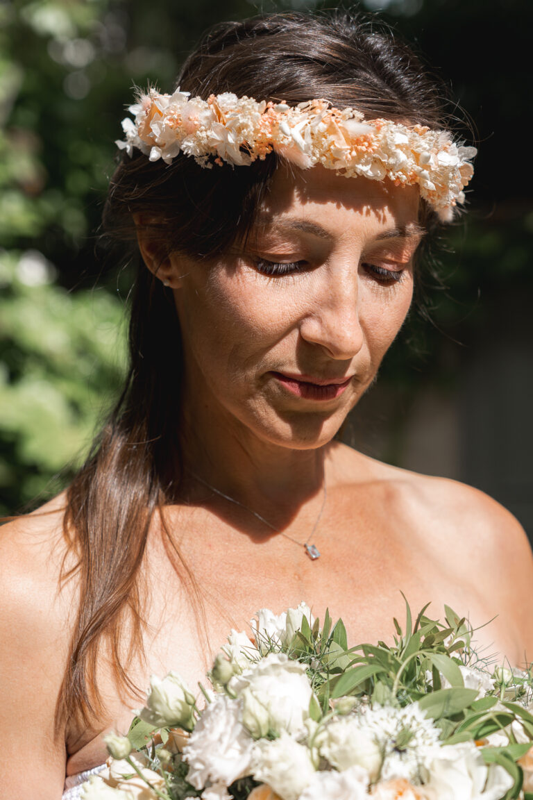 Femme avec une couronne de fleurs qui regarde un bouquet éclairé par le soleil à la maison Mandel de Bordeaux