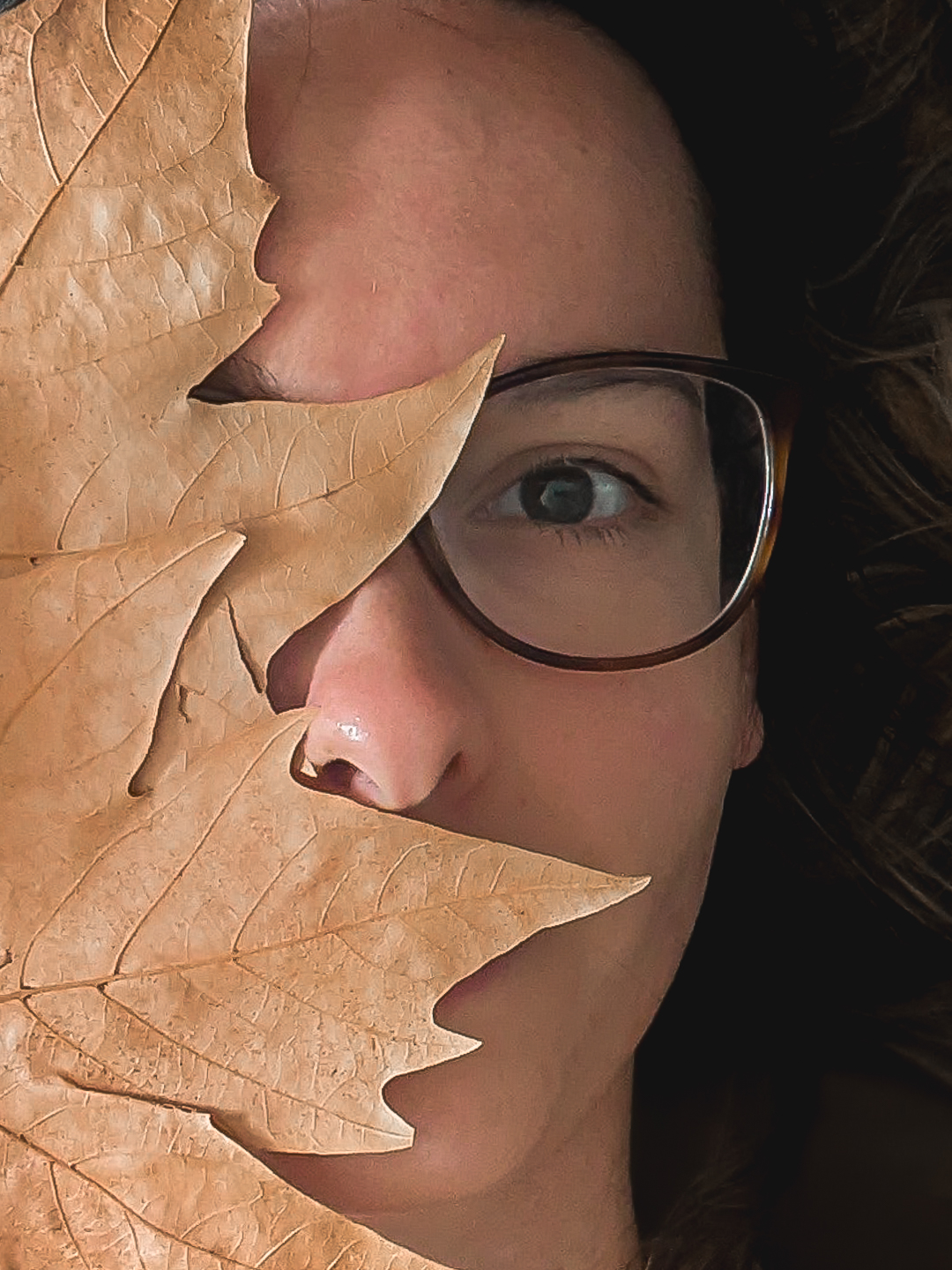 Autoportrait d'une photographe avec des feuilles d'automne à son home studio sur bordeaux