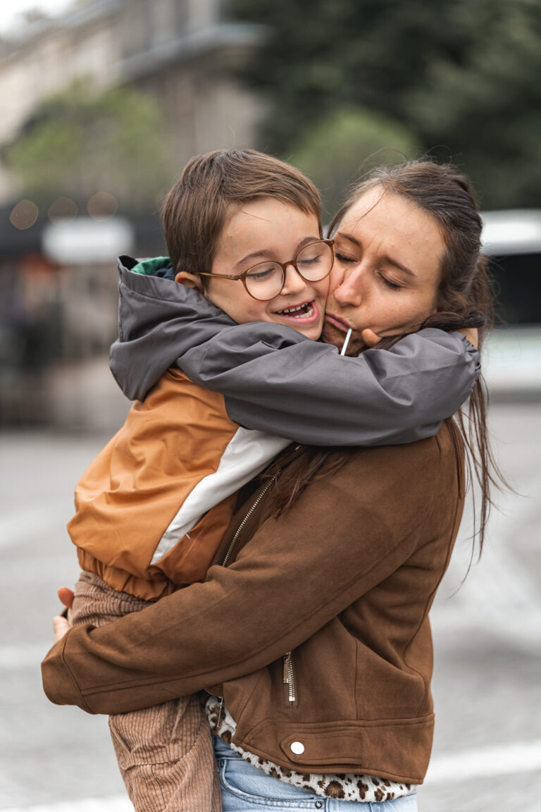 Maman qui câline son petit garçon lors d'une séance photo en famille sur la place de la victoire à Bordeaux