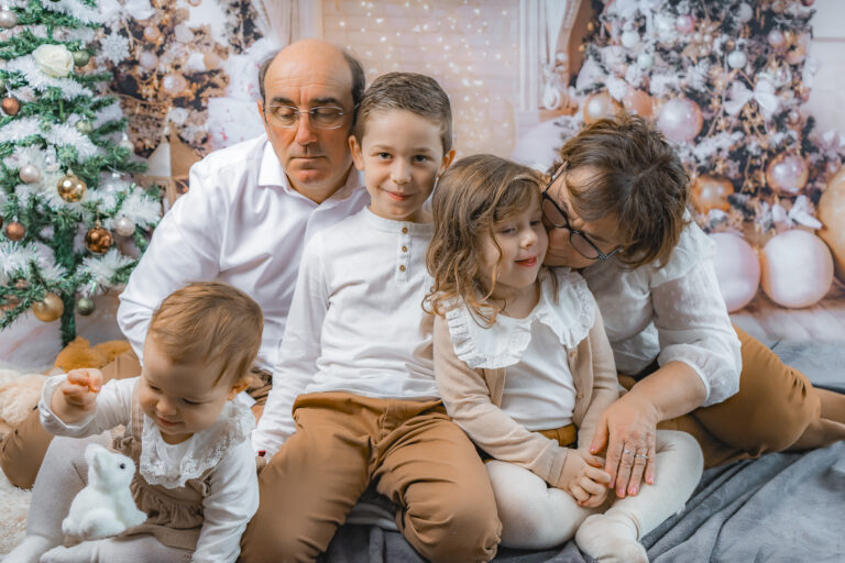 Portrait Famille dans les bras des uns des autres lors de leur séance photo de noël au home studio photos à Bordeaux