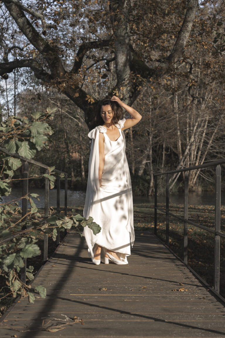 Mariée qui danse sur un pont dans une forêt lors de son portrait de la mariée lors de son mariage laïque au château de Courlat à Lussac