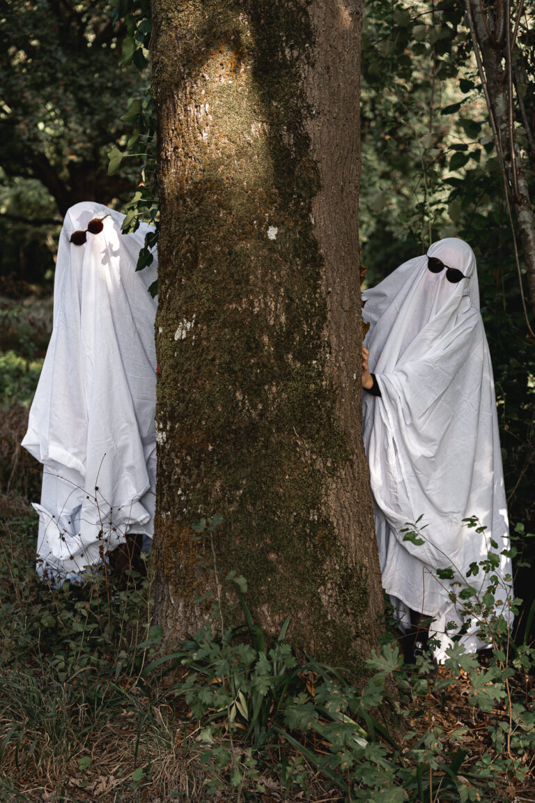 Femmes déguisées en fantômes derrière un arbre lors de leur séance photo halloween en extérieur au parc majolan de Blanquefort