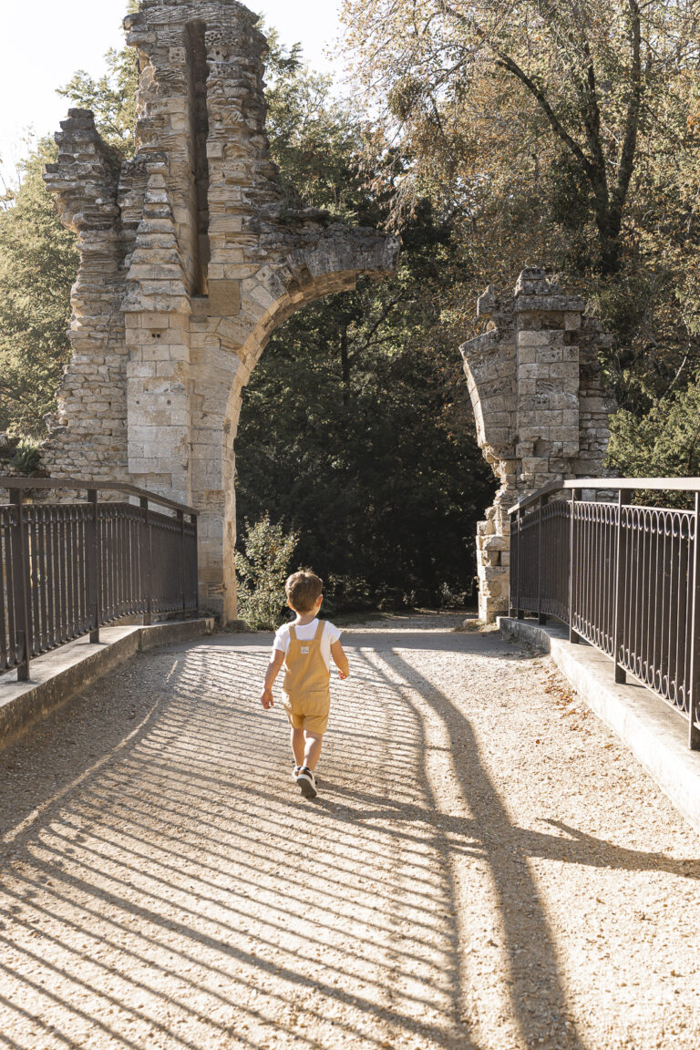 Petit garçon qui court sur un pont lors d'une séance photo en famille dans une forêt du bassin d'arcachon