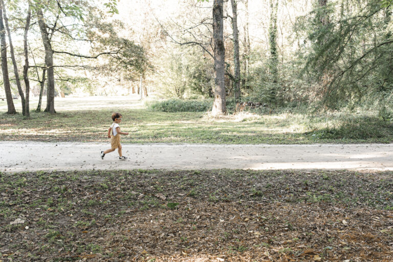 Petit garçon qui court dans le parc de majolan à Blanquefort lors d'une séance photo en famille