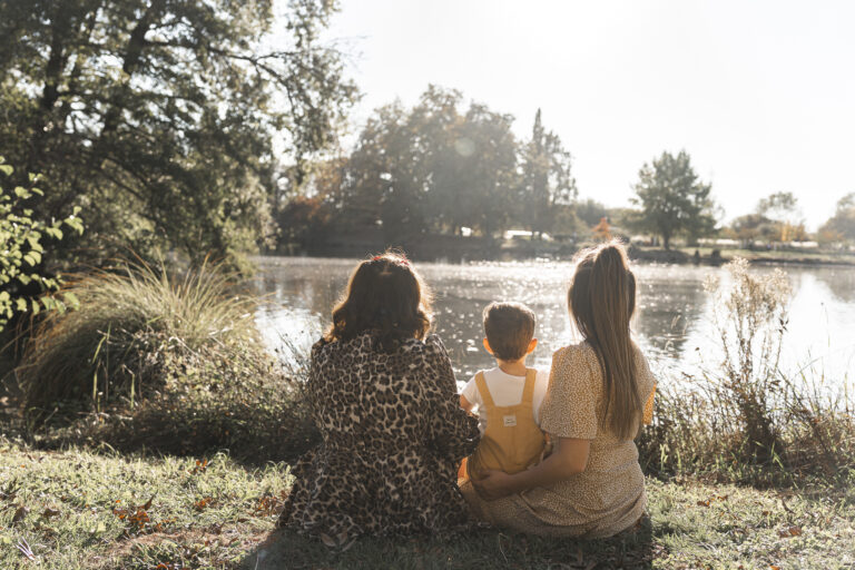 Famille devant un lac du Bassin d'Arcachon au coucher du soleil pendant leur séance photo en famille