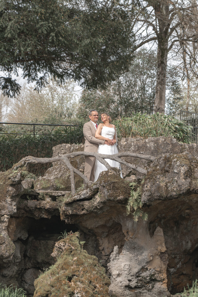 Mariés qui s'enlacent sur un pont en pierre et bois durant la séance photo couple de leur mariage civil à Blanquefort