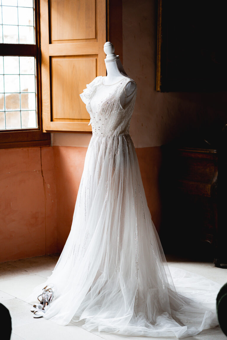 Robe de mariée de marque etcetera showroom sur un mannequin éclairée par la lueur du soleil dans la chambre d'un château de saint-émilion pendant les préparatifs d'un mariage laïque
