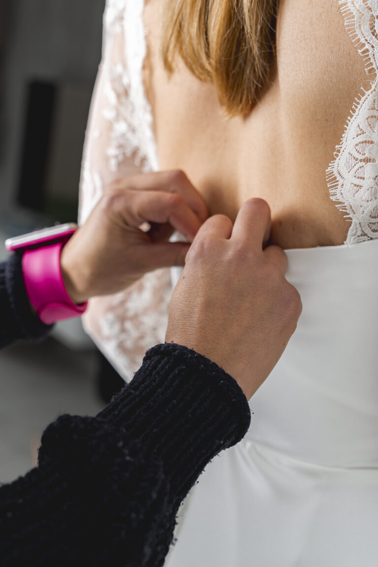 Mise en situation d'une créatrice de robe de mariée qui retouche une robe lors d'une séance photo corporate en immersion à St Sulpice de Cameyrac