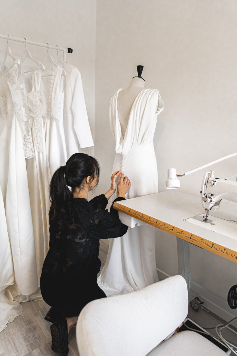 créatrice de robe de mariée qui retouche une robe dans son atelier à Saint sulpice et Cameyrac lors de son shooting corporate en immersion